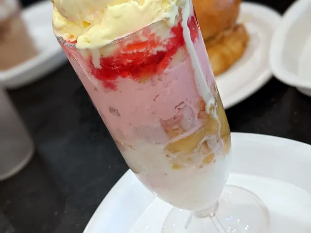 A tall glass of gadbad ice cream layered with jelly and fruit