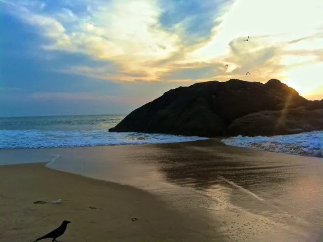 Wet sand and a rocky headland at Kapu in evening light