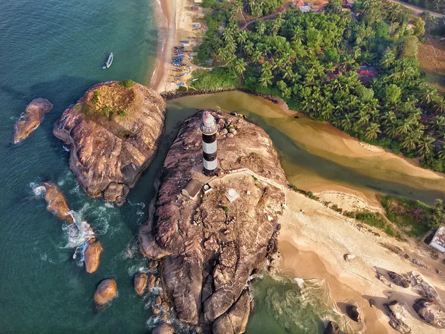 Aerial view of the Kapu lighthouse on its rock, with the beach and a river mouth behind