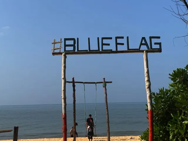 The Blue Flag sign standing on the sand at Padubidri beach