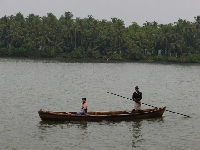 A country boat poled across the Shambhavi backwater near Mulki