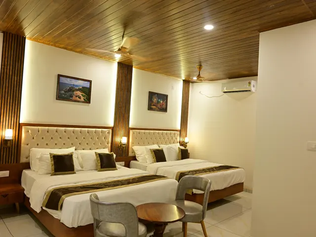 A family room with two double beds under a wood-panelled ceiling